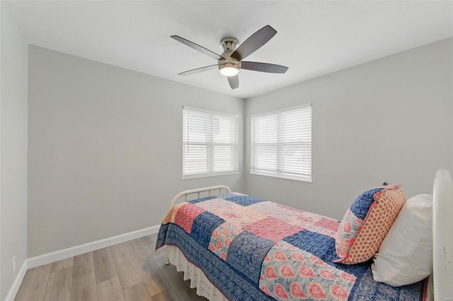 bedroom with ceiling fan, baseboards, and wood finished floors