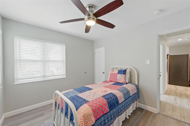 bedroom featuring baseboards, a ceiling fan, and light wood-type flooring
