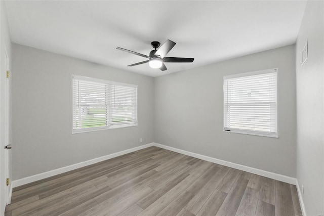 empty room with ceiling fan, baseboards, and wood finished floors