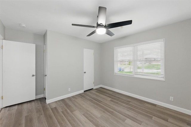 unfurnished bedroom featuring baseboards, a ceiling fan, and wood finished floors