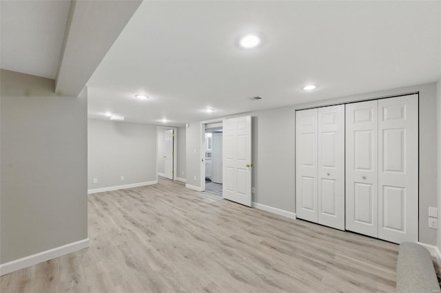 finished basement featuring baseboards, light wood-style floors, and recessed lighting