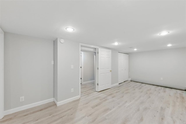 finished basement with recessed lighting, light wood-style floors, and baseboards