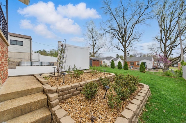 view of yard featuring fence, a residential view, and a patio