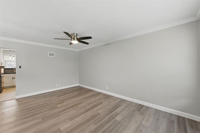 empty room with light wood finished floors, baseboards, visible vents, and ceiling fan