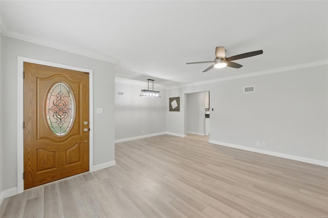 entrance foyer featuring light wood-type flooring, ceiling fan, baseboards, ornamental molding, and visible vents