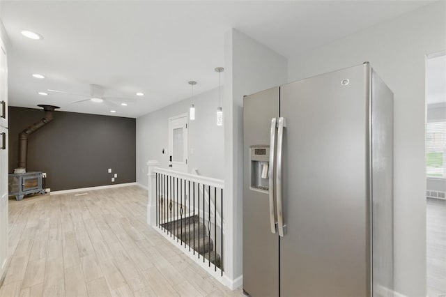 hall featuring an upstairs landing, baseboards, light wood-style floors, and recessed lighting