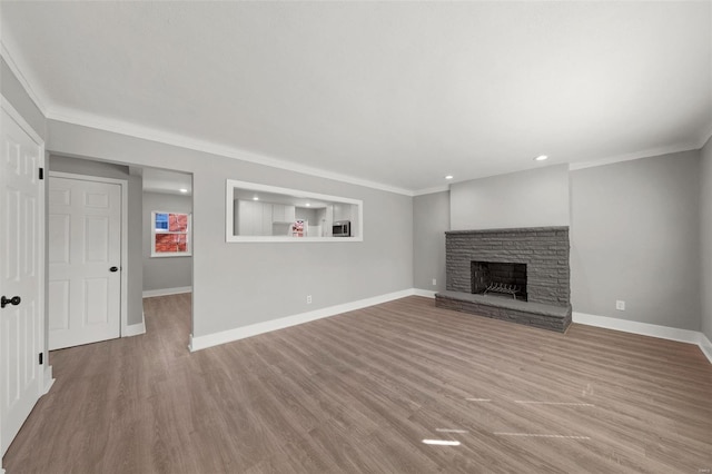 unfurnished living room with baseboards, crown molding, and wood finished floors