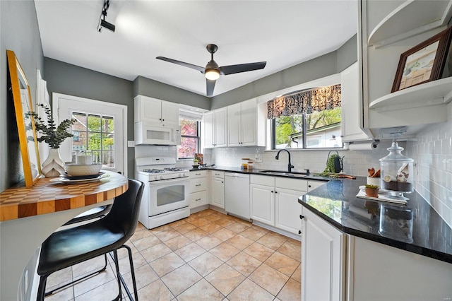 kitchen featuring a sink, decorative backsplash, white appliances, and white cabinets