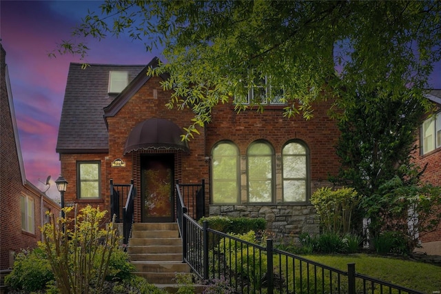 view of front of house with fence and brick siding