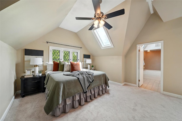 bedroom featuring vaulted ceiling with skylight, carpet floors, baseboards, and ceiling fan