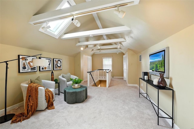 living area with rail lighting, baseboards, lofted ceiling with skylight, an upstairs landing, and carpet