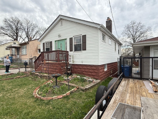 bungalow-style house featuring a chimney and a front yard
