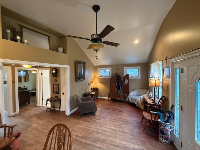 bedroom with a ceiling fan, high vaulted ceiling, baseboards, and wood finished floors