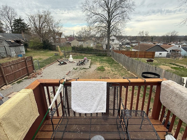 wooden terrace featuring a fenced backyard, a residential view, and a yard