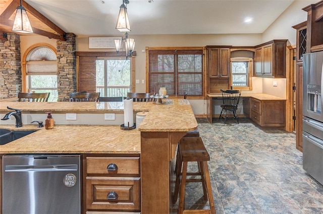 kitchen featuring hanging light fixtures, a sink, appliances with stainless steel finishes, and lofted ceiling