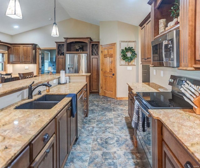 kitchen featuring hanging light fixtures, light stone counters, appliances with stainless steel finishes, vaulted ceiling, and a sink