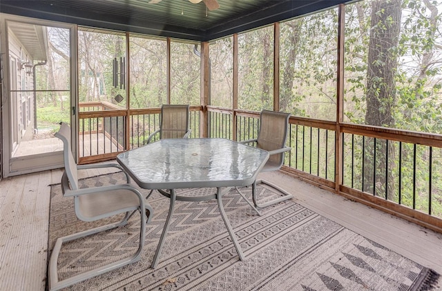 sunroom with outdoor dining space and a ceiling fan