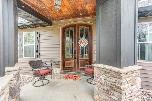 property entrance featuring covered porch and french doors