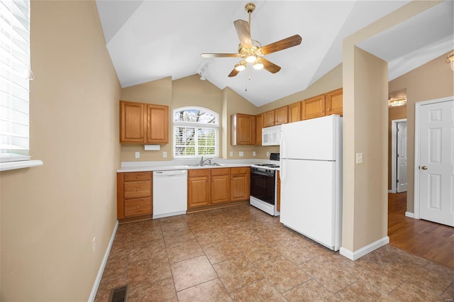 kitchen featuring ceiling fan, a sink, white appliances, light countertops, and baseboards