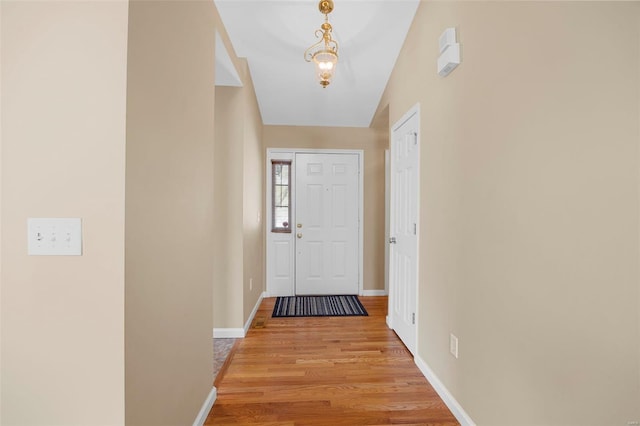 doorway featuring baseboards and light wood-style flooring
