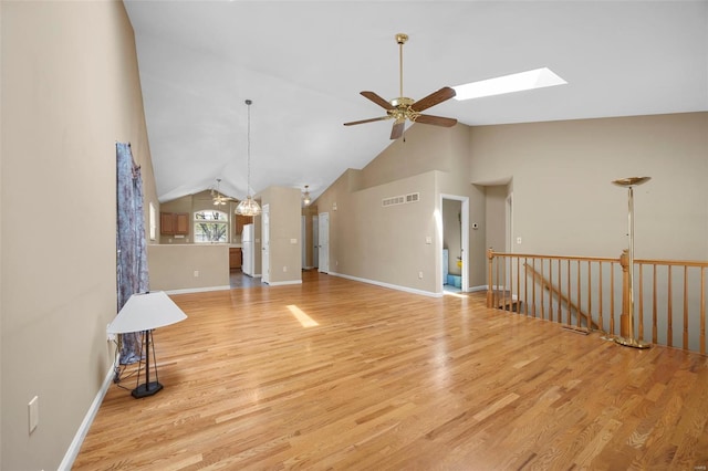 unfurnished living room with baseboards, a ceiling fan, lofted ceiling with skylight, and light wood-style flooring
