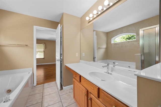 full bath featuring a whirlpool tub, tile patterned floors, a wealth of natural light, and vanity