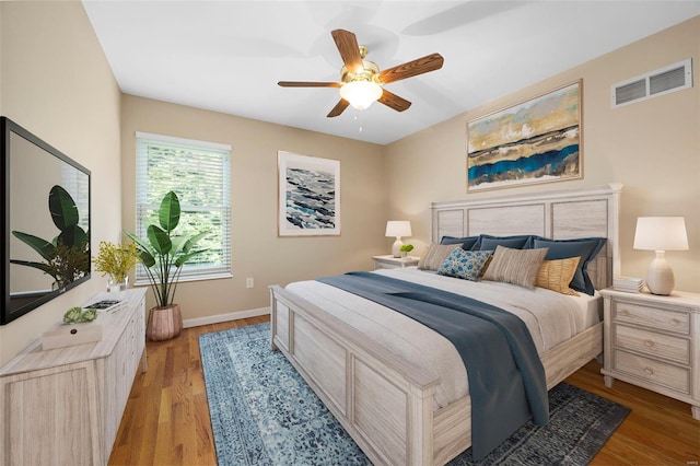 bedroom featuring a ceiling fan, baseboards, visible vents, and light wood finished floors