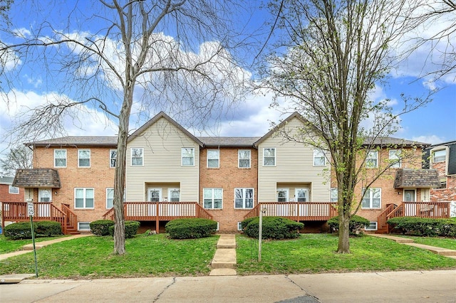 view of front of home featuring brick siding and a front yard