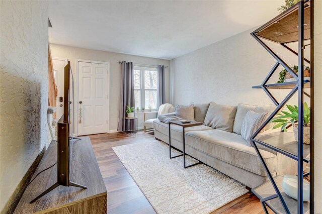 living area with a textured wall and wood finished floors