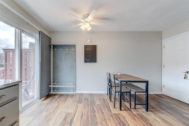 dining space featuring baseboards, wood finished floors, and ceiling fan