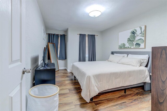 bedroom with baseboards and wood finished floors