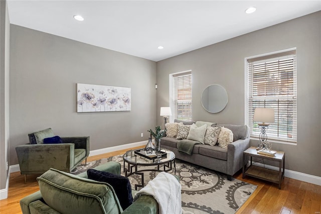 living area featuring recessed lighting, baseboards, light wood-style flooring, and a healthy amount of sunlight
