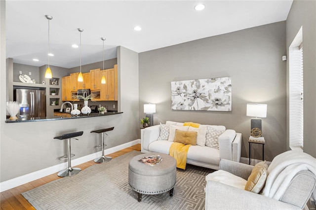 living area featuring wood finished floors, recessed lighting, and baseboards