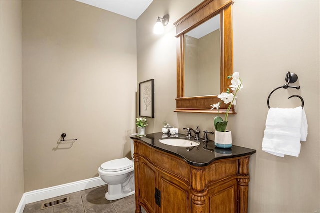 bathroom featuring vanity, tile patterned floors, toilet, visible vents, and baseboards