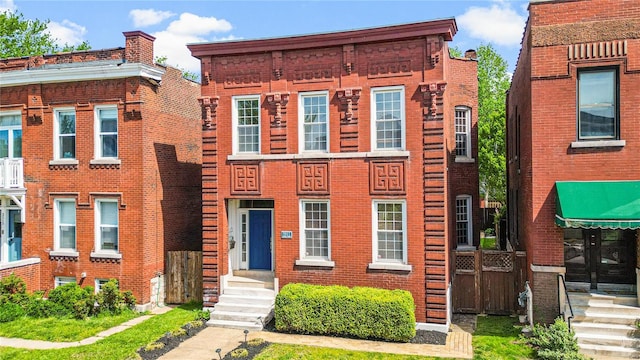 townhome / multi-family property with entry steps and brick siding