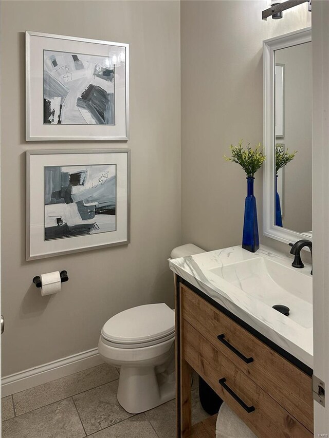 bathroom with tile patterned floors, toilet, vanity, and baseboards