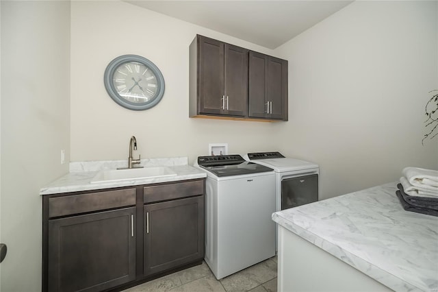 clothes washing area with washing machine and dryer, a sink, and cabinet space