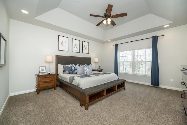 carpeted bedroom featuring a tray ceiling, baseboards, and recessed lighting