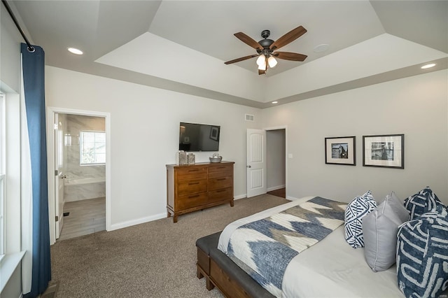 carpeted bedroom featuring ensuite bathroom, baseboards, visible vents, a tray ceiling, and recessed lighting