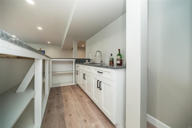 bar with recessed lighting, light wood-style floors, a sink, and bar