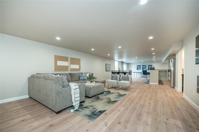living area with light wood finished floors, baseboards, and recessed lighting