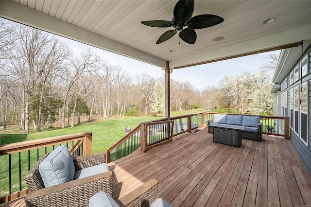 wooden terrace featuring an outdoor living space, a yard, and ceiling fan