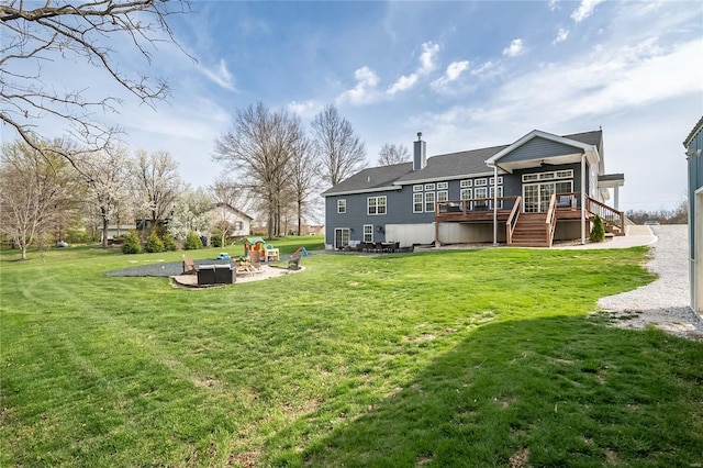 back of house with a patio, stairway, a wooden deck, an outdoor fire pit, and a lawn