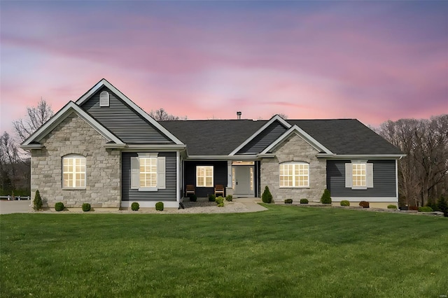 ranch-style house featuring stone siding and a lawn