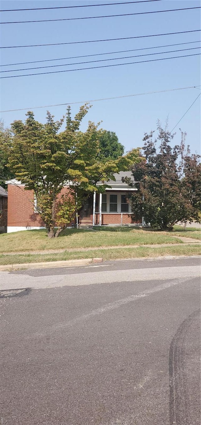 obstructed view of property featuring a front lawn