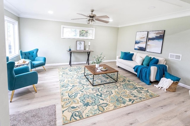 living area with crown molding, baseboards, a ceiling fan, and wood finished floors