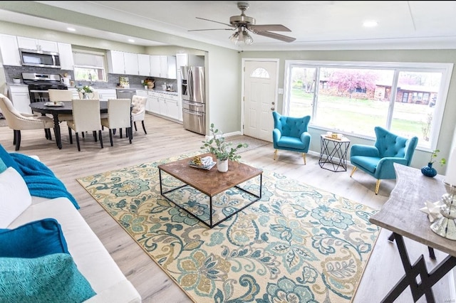 living area with light wood-style flooring, ceiling fan, baseboards, and recessed lighting