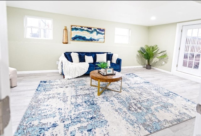living room featuring a wealth of natural light, baseboards, and wood finished floors