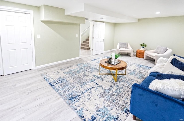 living area with wood finished floors, recessed lighting, baseboards, and stairs