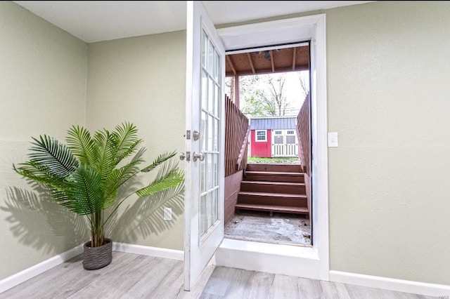 entryway featuring french doors, baseboards, stairway, and wood finished floors